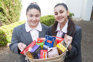 Students at Mary MacKillop Catholic College Wakeley holding basket of food for donation